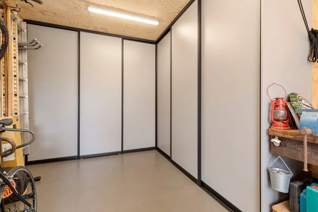 Een moderne kast in de garage, ideaal om spullen op te bergen. Fietsen en gereedschap staan netjes opgesteld.