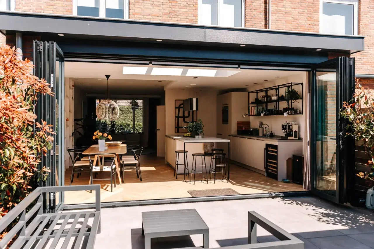 Moderne keuken en eethoek in een vergunningsvrij uitgebouwde achterzijde woning, met vouwdeuren naar terras.