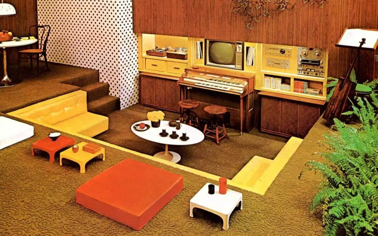 Een retro woonkamer met een **zitkuil jaren 70**, oranje en gele meubels, een orgel en een tv.