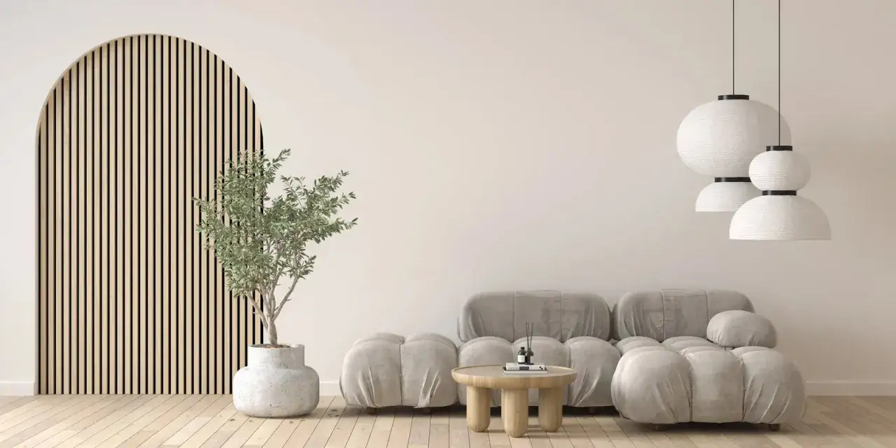 Een woonkamer in Japans minimalisme met een ronde houten wand, grijze plofbank, ronde salontafel en witte hanglampen.