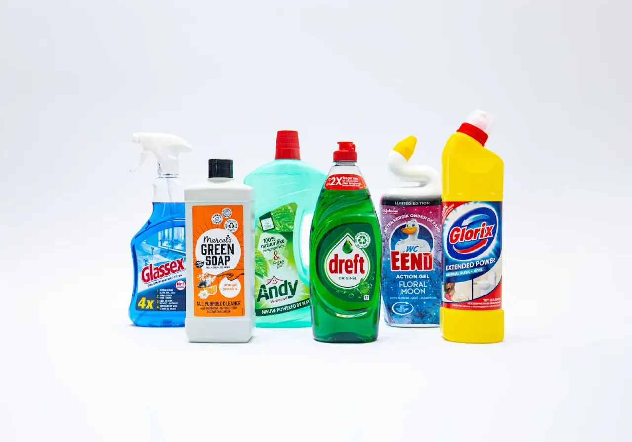 Een rij schoonmaakmiddelen, waaronder Dreft en Glorix, voor duurzaam schoonmaken.