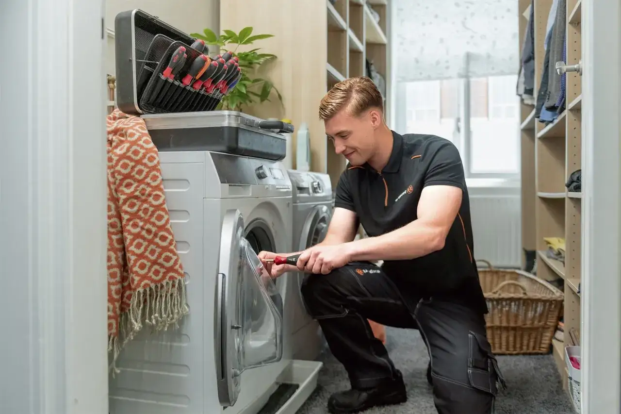 Monteur lost wasmachine problemen op met gereedschap.