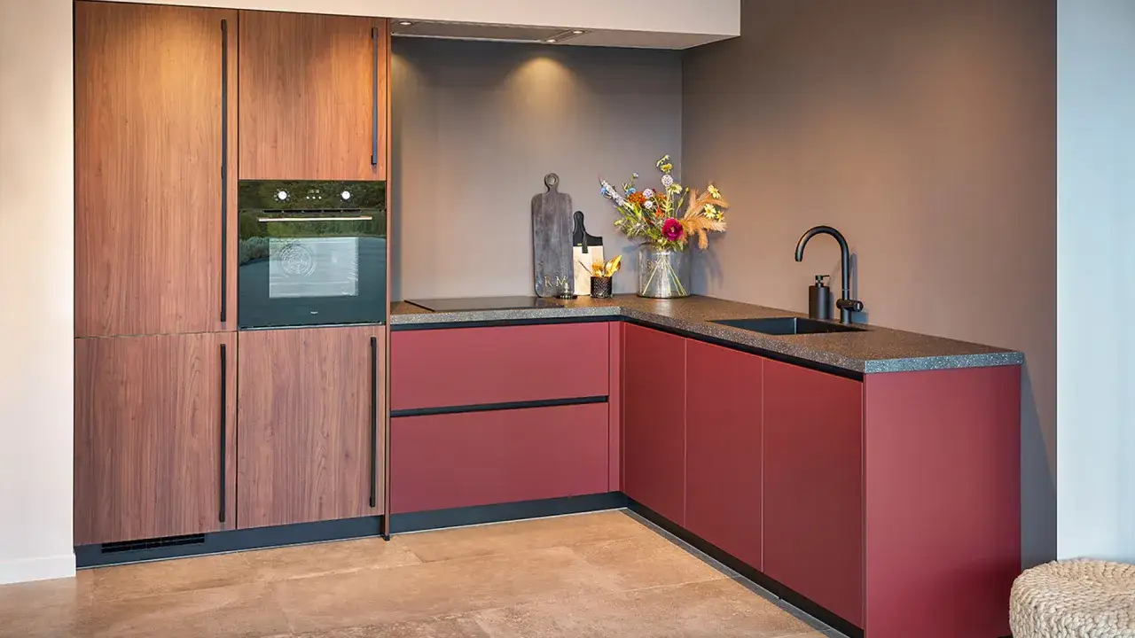 Moderne keuken met houten kasten en rode onderkasten. Een stijlvolle 2 kleuren keuken die warmte en kleur combineert.