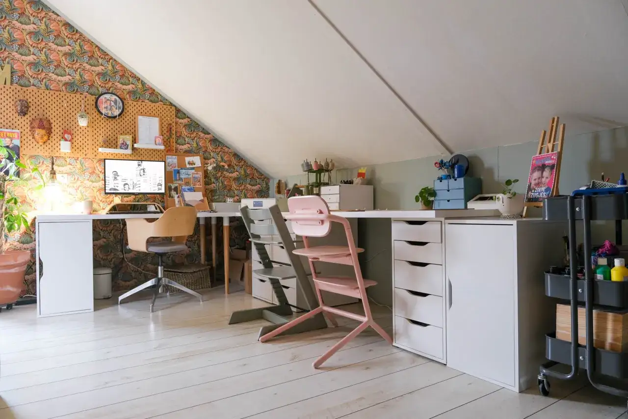 Een creatieve zolderruimte met bureaus, stoelen en opbergkasten. Een inspirerende plek om op te ruimen voor je doodgaat.