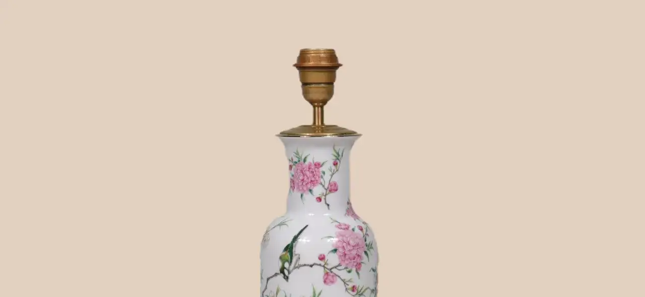 Een sierlijke vaas, versierd met roze pioenrozen en een vogel, is omgebouwd tot een lamp.