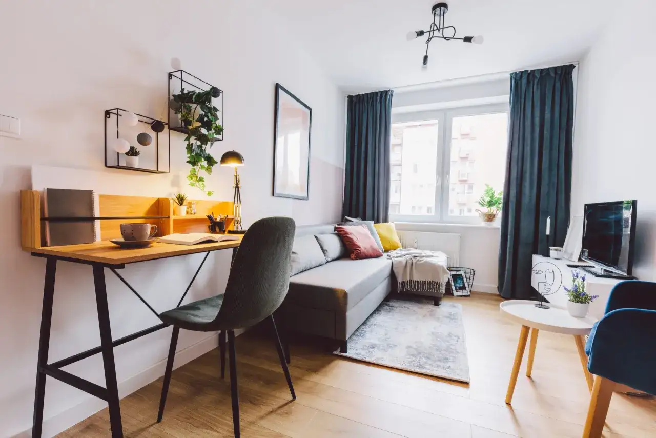 Gezellige woonkamer met bureau, bank en tv. Perfect voor een uitzetlijst huis.