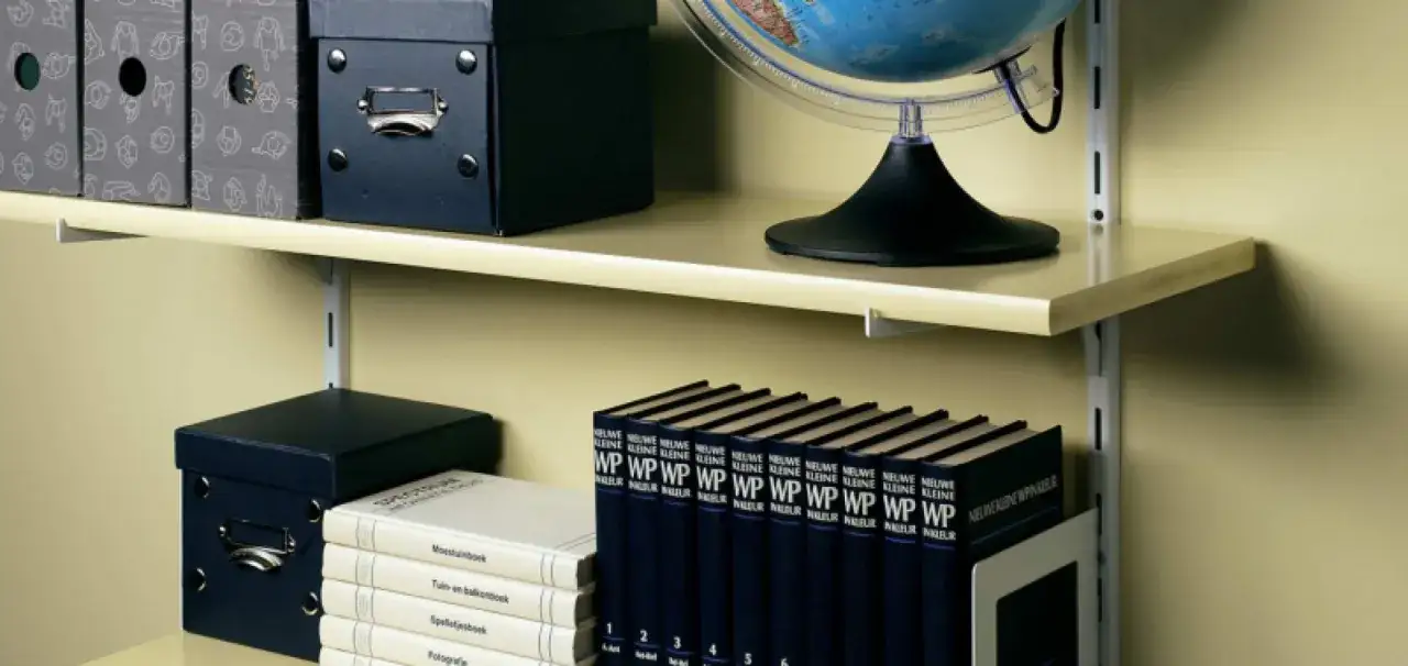 Netjes schoolboeken opbergen op de plank. Naast stapels boeken en een globe, vind je hier ook handige opbergdozen.