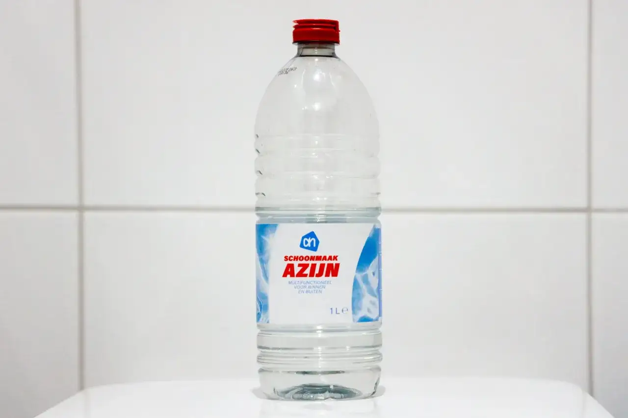 Fles schoonmaakazijn, ideaal voor het wassen van nieuwe handdoeken.