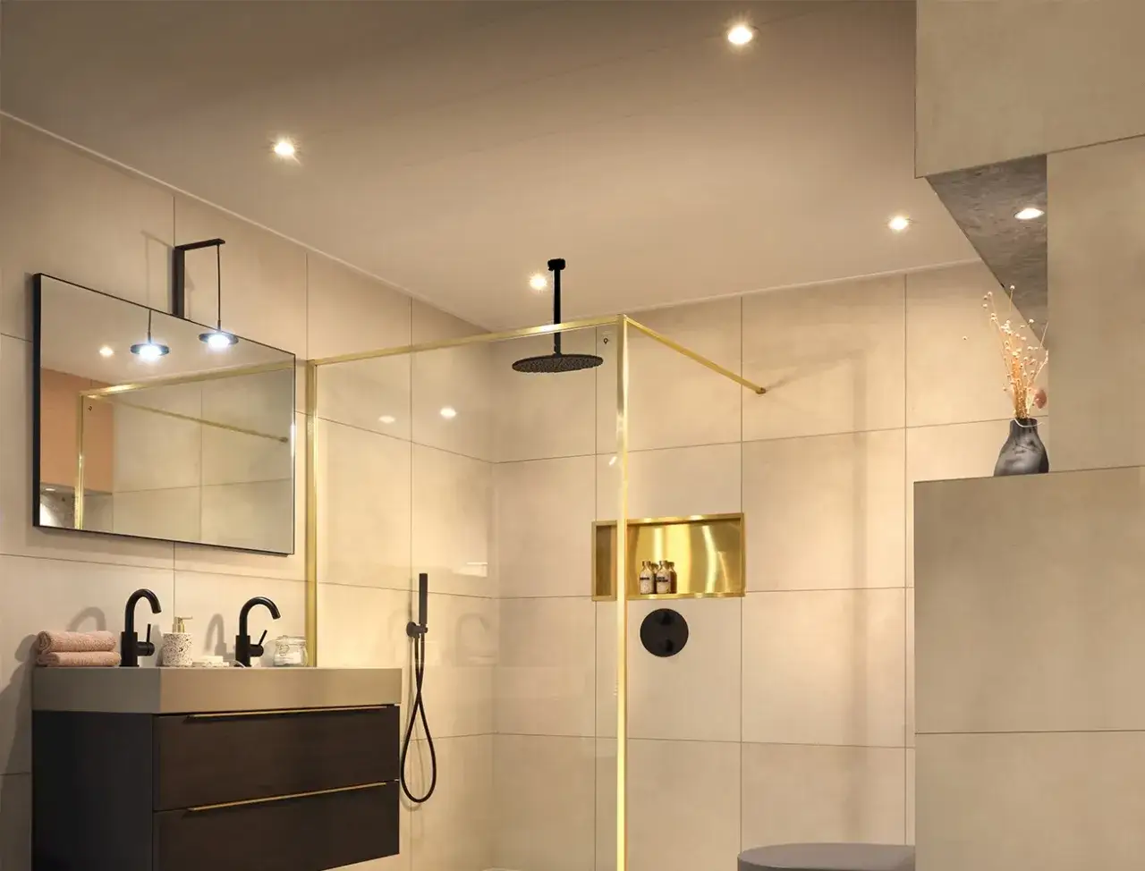 Moderne badkamer met beige tegels, gouden accenten en een douche. Het plafond is strak afgewerkt, wat het plafond tegelen een luxe uitstraling geeft.