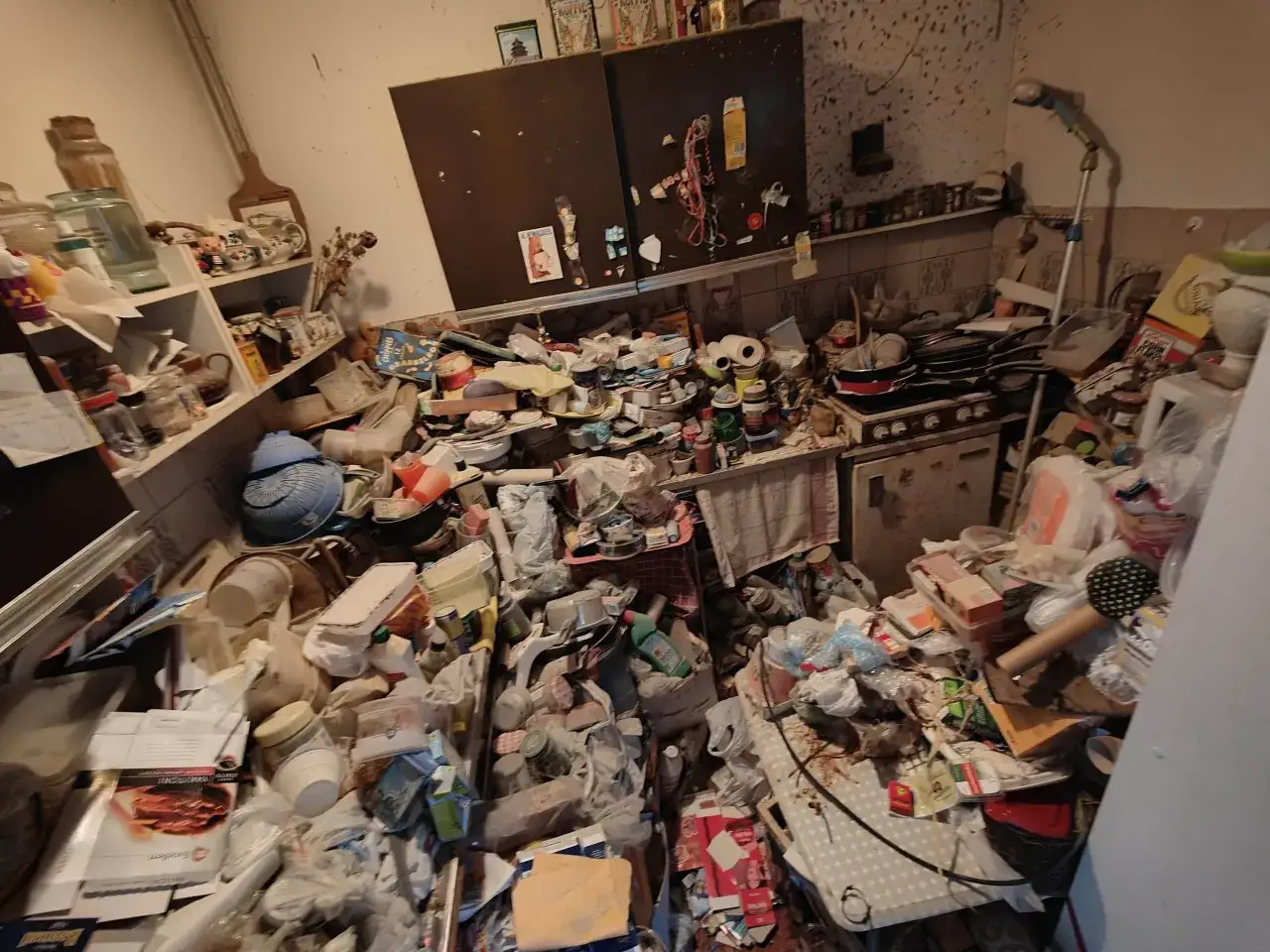 Een keuken vol spullen, een beeld dat de ware hoarders betekenis illustreert. Overal liggen verpakkingen, potten en pannen.