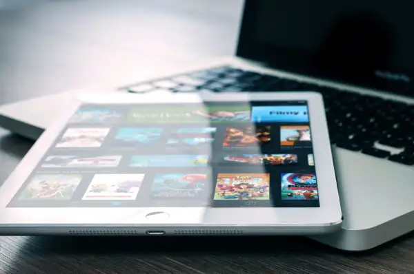 Tablet met filmscherm naast laptop. Een digitale collectie films, een moderne manier om cd's weggooien of bewaren te vermijden.