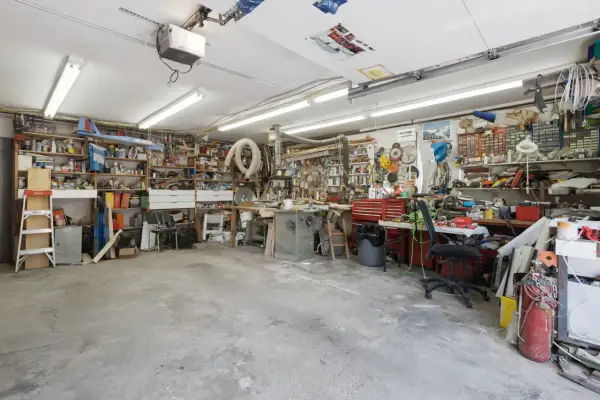 Een georganiseerde garage met motor, fietswielen, helmen, ballen en posters. Inspirerende garage ideeen voor elke hobbyist.