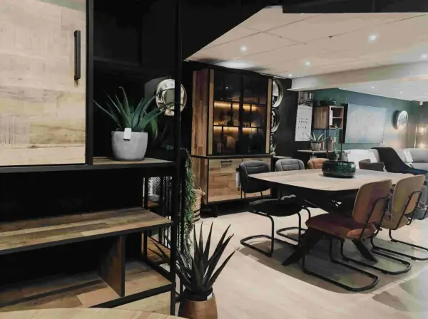 Een sfeervolle woonkamer met een **donker hout keuken** element, een eettafel met stoelen en planten.