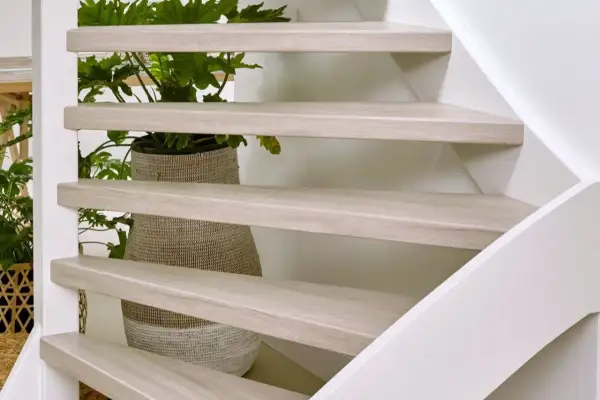 Lichte houten traptreden met planten erachter. Inspiratie voor open trap opknappen ideeën.