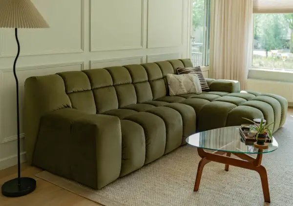Een olijfgroene bank met zachte kussens, de perfecte basis. Welke kleur past bij groene bank? Denk aan warme aardetinten of frisse pastels voor een harmonieus interieur.