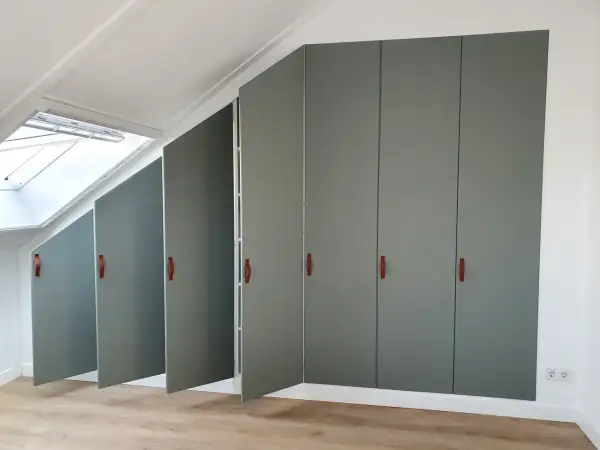 Moderne grijze kasten met leren handgrepen, perfect voor de achterkant kast afwerken. Een dakraam zorgt voor natuurlijk licht.