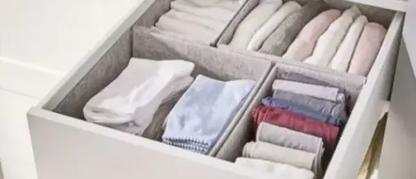 Een opgeruimde lade met netjes gevouwen kleding, geïnspireerd door de Marie Kondo methode. Kledingkast organizers houden alles netjes.