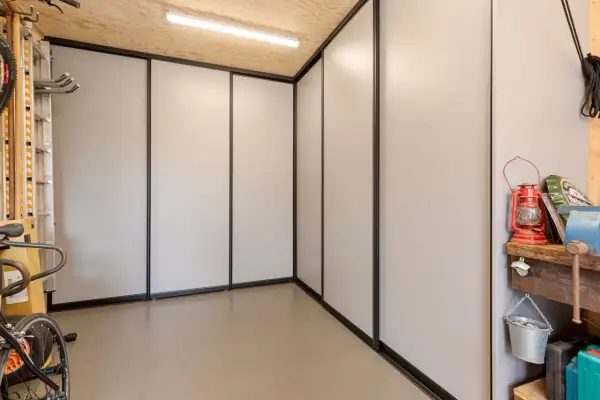 Een moderne kast in de garage, ideaal om spullen op te bergen. Fietsen en gereedschap staan netjes opgesteld.