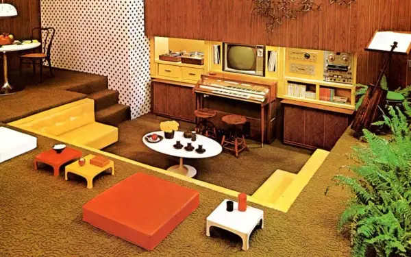 Een retro woonkamer met een **zitkuil jaren 70**, oranje en gele meubels, een orgel en een tv.