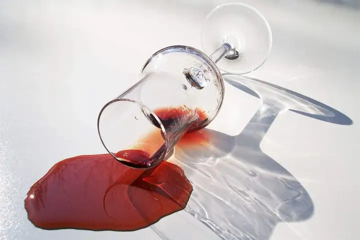 Om een opgedroogde rode wijnvlek te verwijderen, zoals tante Kaat ons leerde, is dit de situatie: een omgevallen glas rode wijn op een witte ondergrond.